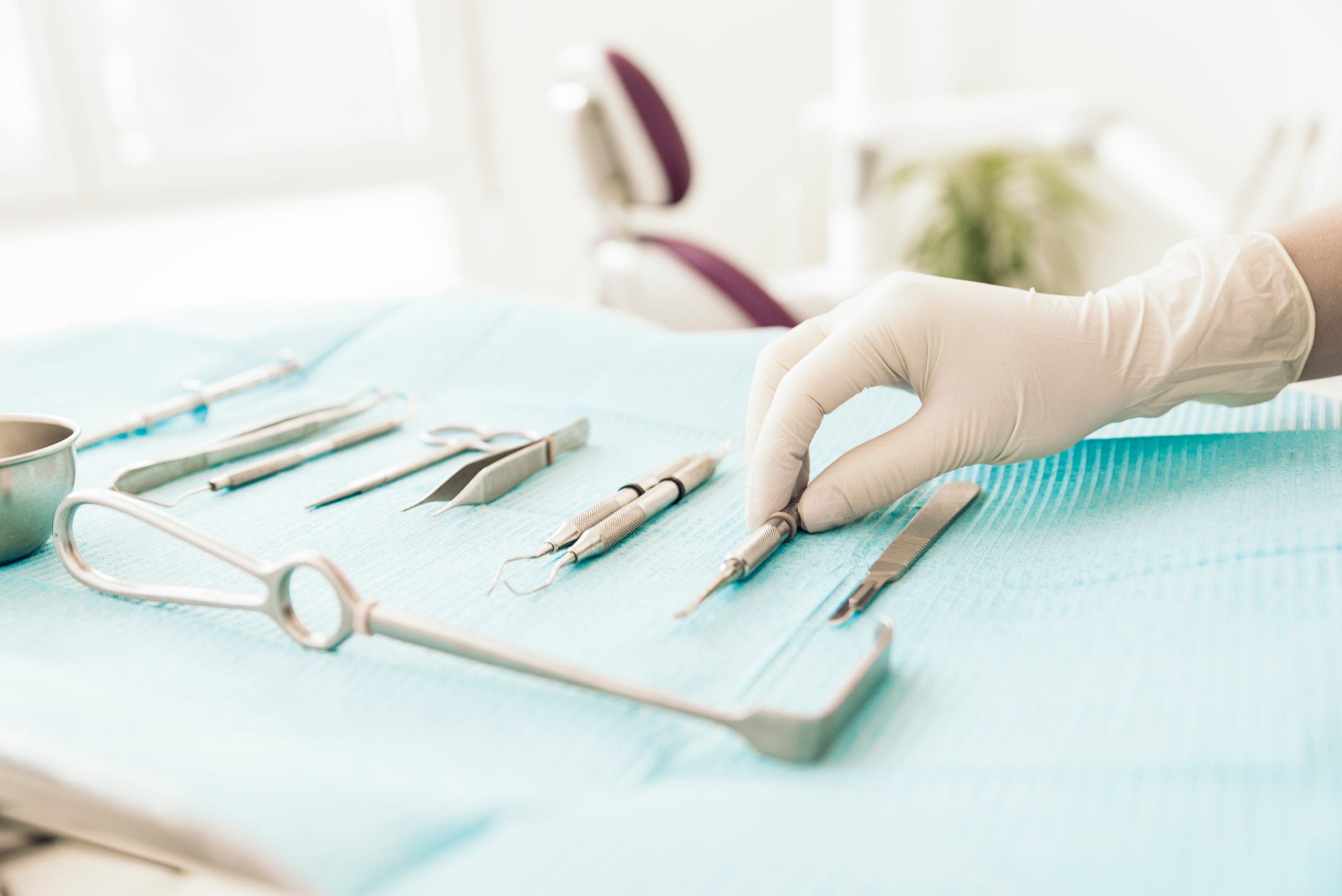 Detail of hand holding dental tools in dental clinic.
